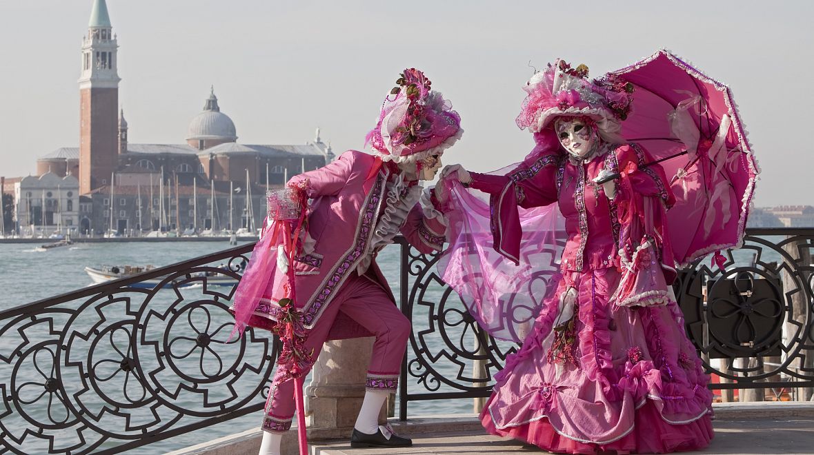 Nábřeží karnevalových Benátek a sladěný pár v kostýmech