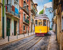 Tradiční lisabonská tramvaj prochází atmosférickou čtvrtí Alfama