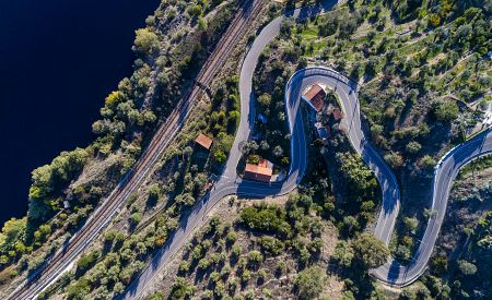 Letecký pohled na klikatou silnici a vlakové tratě podél řeky Tajo poblíž vesnice Belver v Portugalsku