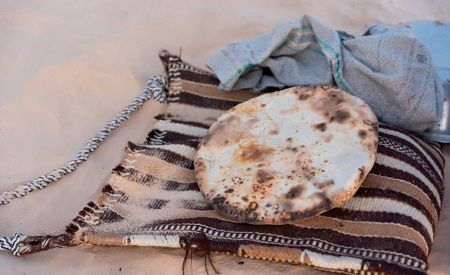 Ukázka přípravy chleba pečeného v rozpáleném písku v táboře Tuaregů