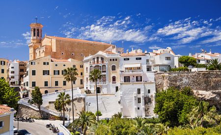 Sluncem zalité uličky menorského hlavního města Mahón s kostelem Santa María