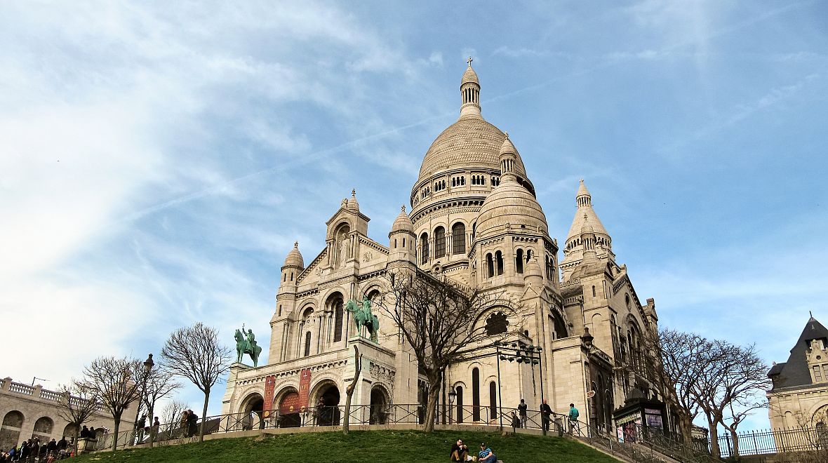 Bělostná bazilika Sacré Coeur tyčící se nad Paříží