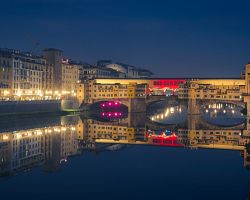 Nádherně nasvícené florentské nábřeží a most Ponte Vecchio v době adventu