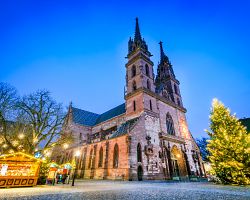 Rozzářené náměstí Münsterplatz v Basileji s vánočním stromy a adventními stánky