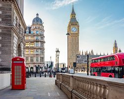 Hodinová věž Houses of Parliament s červenou budkou a doubledeckerem v Londýně