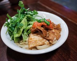 Tradiční rýžové nudle cao lau z Hoi An podávané s vepřovým masem a bylinkami