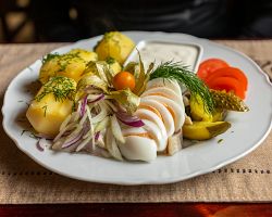 Tradiční estonská chuťovka – marinovaný sleď s cibulí a brambory