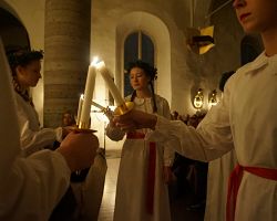 Dívky se svíčkami při oslavě švédského svátku svaté Lucie