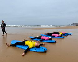 Rozcvička na algarvské pláži před surfováním v Atlantiku
