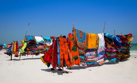 Keňské pestrobarevné tkaniny na pláži v Mombase