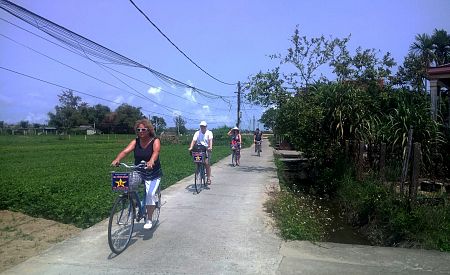 Naši cestovatelé při projížďce na kole rýžovými políčky na pláž v Hoi An