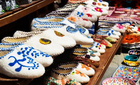 Ručně tkané pantofle s různými barevnými vzory na bazaru v Gjirokastře
