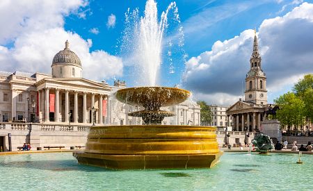 Fontána na londýnském náměstí Trafalgar Square s Národní galerií v pozadí