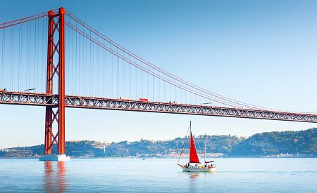 Ikonický ocelový most Ponte 25 de Abril spojující Lisabon a město Almada v Portugalsku