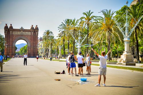 Pouliční artisti na promenádě s Vítězným obloukem v Barceloně