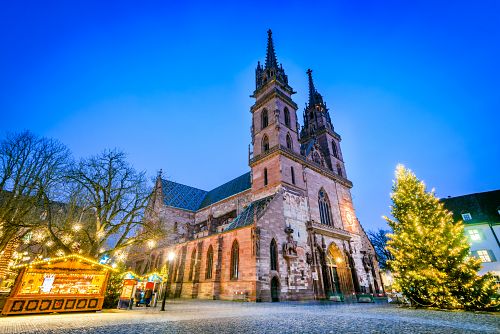 Rozzářené náměstí Münsterplatz v Basileji s vánočním stromy a adventními stánky