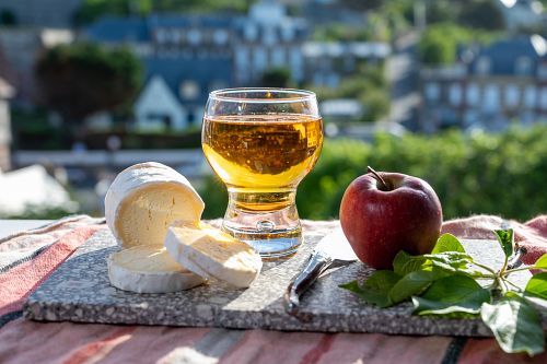 Tradiční produkty Normandie – sýr a sklenka jablečného cideru
