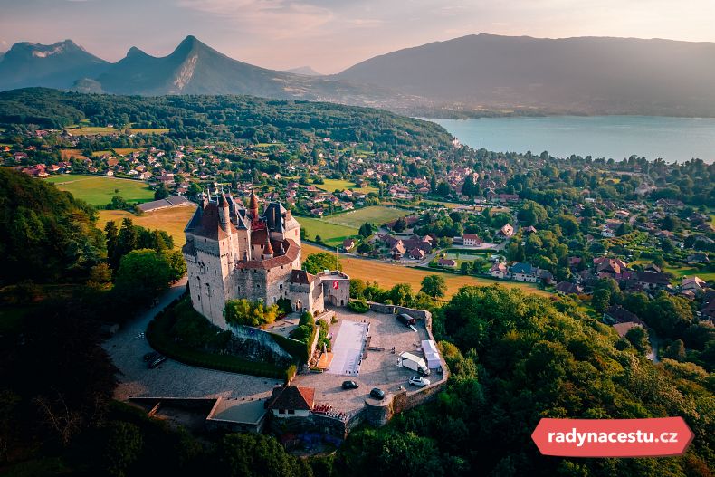 Letecký snímek hradu Menthon-Saint-Bernard s výhledem na město a jezero v Annecy
